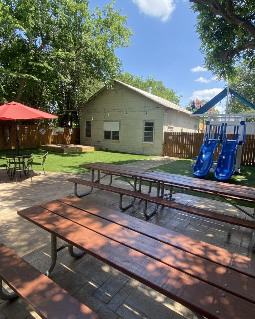 Outdoor dining at Bootleggers Pizza Parlor, complete with a kid-friendly slide that makes it easy for families to relax and enjoy. Credit: @bootleggers_pizza_parlor via Instagram