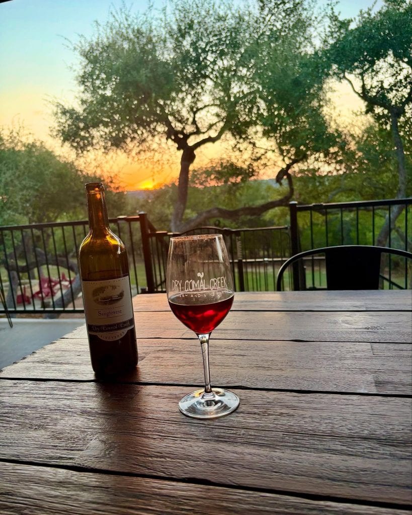 A perfect post-hike moment: wine, nature, and a stunning view at Dry Comal Creek Vineyard. Credit: @cotesducomal via Instagram