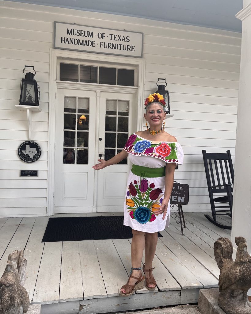 A volunteer docent warmly welcomes visitors to the Museum of Texas Handmade Furniture. Credit: @heritagevillagenb via Instagram