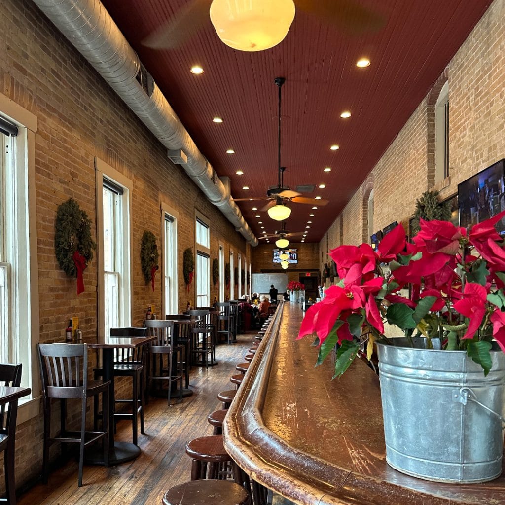 Inside Mozie’s, a long bar serves up cocktails while tables for two offer a cozy dining experience. Credit: @moziesingruene via Instagram