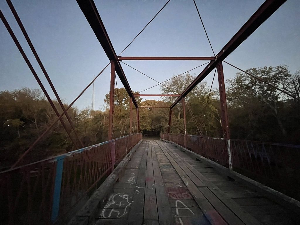 Known for eerie tales and urban legends, Old Alton Bridge now sits covered in student scribbles and spray-painted marks — its quiet woods adding to the chill. Credit: Mike Mayberry via Facebook