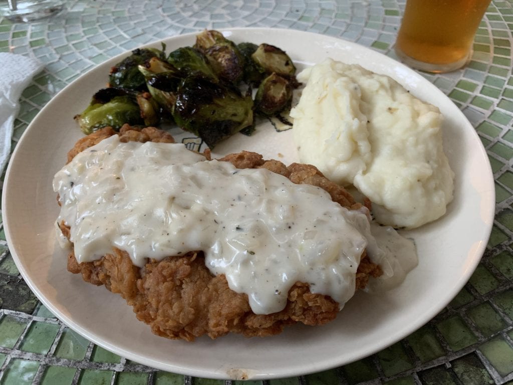 Crispy chicken-fried steak served with creamy mashed potatoes and savory roasted Brussels sprouts. Credit: u/BlackoutGunshot via r/food