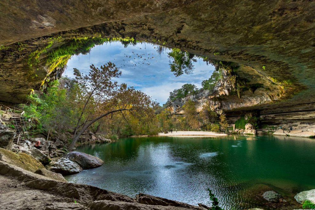 Hamilton Pool Preserve captivates with its otherworldly beauty—emerald waters, dramatic limestone cliffs, and a natural grotto that feels like stepping into another world.