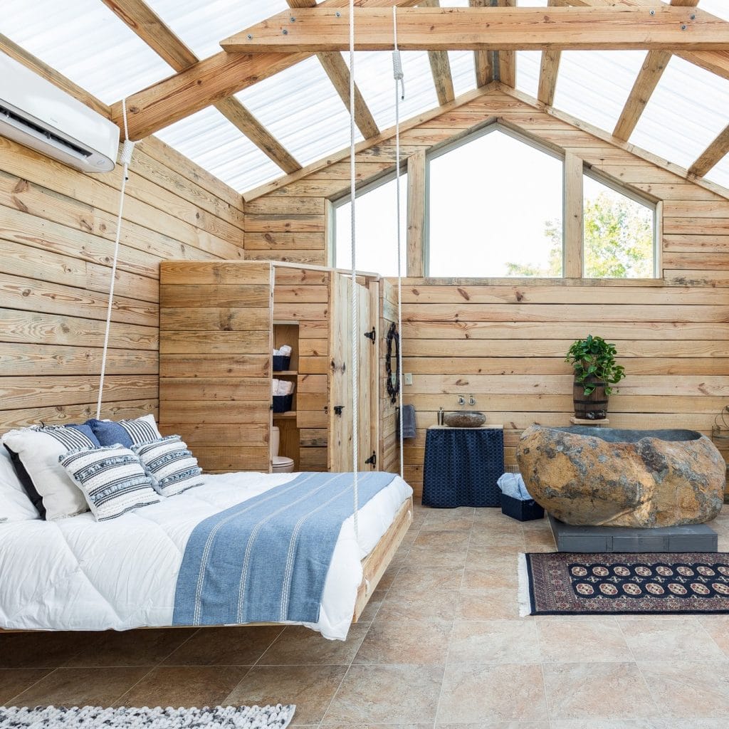 A fresh, airy room at Naturalist Boudoir in Lumberton—wooden cabin vibes, nature-inspired décor, and a stone-style bathtub. Credit: @naturalistboudoir via Instagram