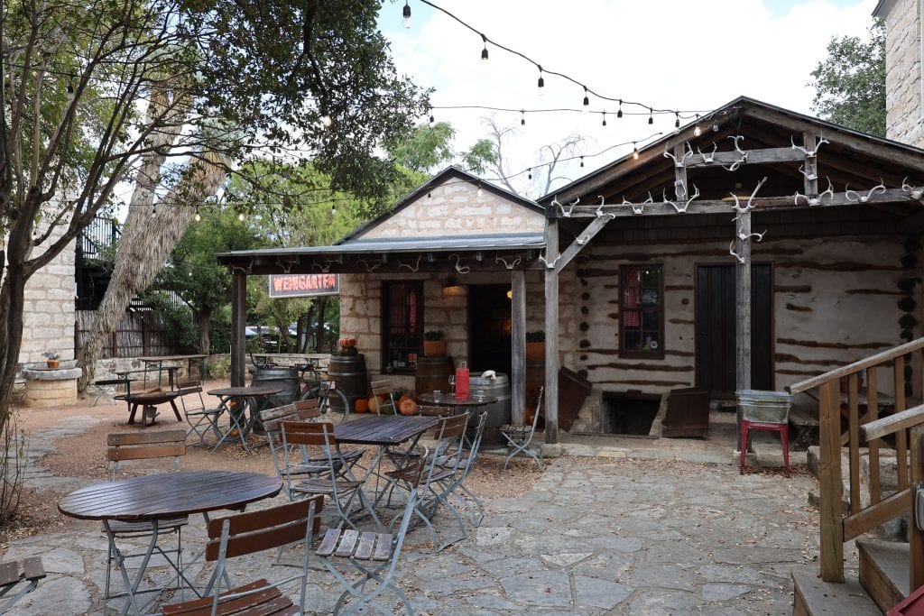 The cozy cottage wine garden at Pontotoc Vineyard, featuring a stone-walled courtyard perfect for outdoor dining. Credit: @visitfredtx via Instagram