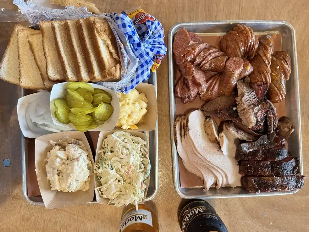 This Southside Market platter showcases Elgin BBQ at its best—legendary sausage alongside brisket, pork, and comforting sides. Credit: u/Surferbum08 via r/BBQ
