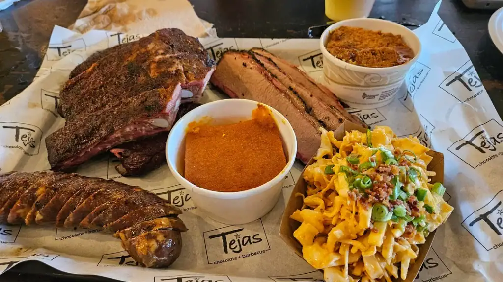 A full BBQ feast at Tejas Chocolate & Barbecue with brisket, ribs, Chile Relleno sausage, sides, and brisket tacos. Credit: u/SrMalarkey via r/BBQ 