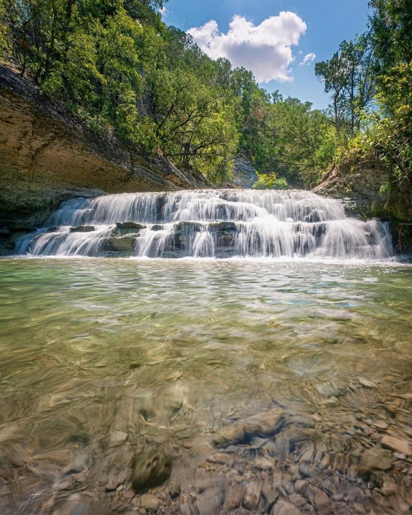 Waterfalls in Texas? Absolutely. Chalk Ridge Falls is just one of many natural surprises beyond the “cowboy desert” stereotype. Credit: @only.in.texas via Instagram