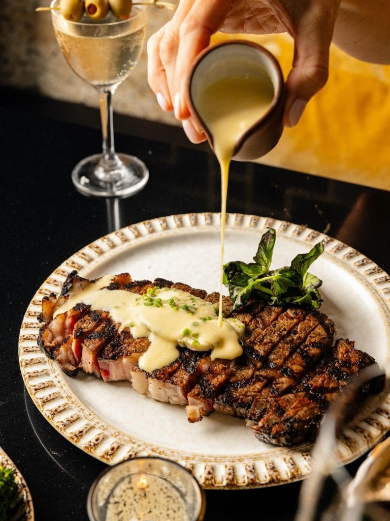 The Duchess at the Nobleman Hotel serves up a perfectly cooked New York Strip topped with decadent, creamy sauce. Credit: @duchess.thenobleman via Instagram