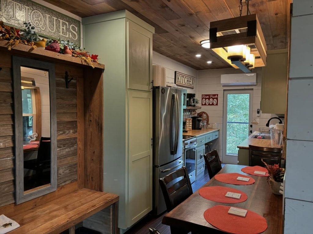 Cozy wooden cabin kitchen and dining area at the Air Castle. Fully equipped with refrigerator, oven, and all the essentials—rustic but functional. Credit: @highpointtreehouses via Instagram