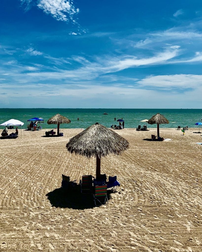 Rockport Beach under clear blue skies, with shaded huts perfect for sitting back, relaxing, and taking in the coastal views. Credit: @dallaswanderer via Instagram