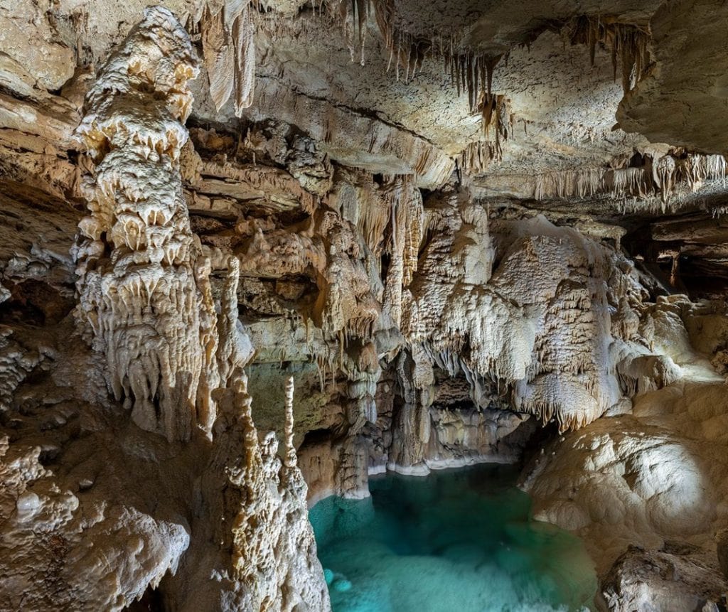 A surreal view of Emerald Lake inside Natural Bridge Caverns, featuring striking formations and impossibly clear blue water. Credit: @naturalbridgecaverns via Instagram