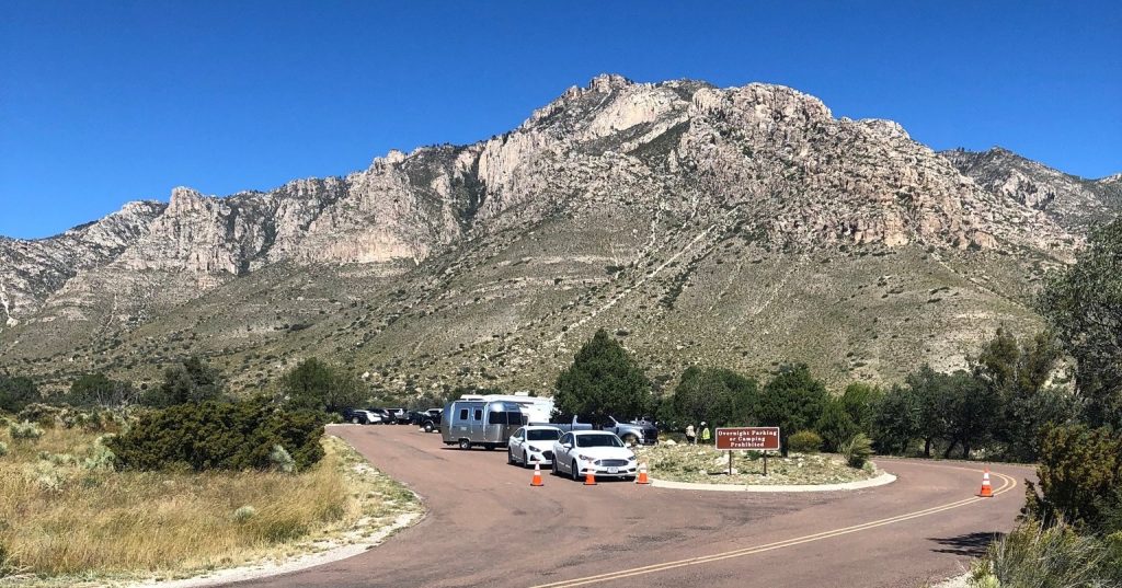 A wide view of the stunning peaks of the Guadalupe Mountains—cars along the road look tiny against the sheer scale of the landscape. Credit: @guadalupemountainsnps via Instagram