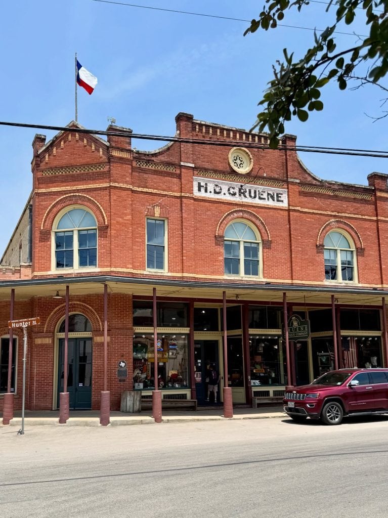 The historic H.D. Gruene Mercantile, with its classic red-brick façade, offers unique home goods, gifts, and souvenirs—one of the many charming stops in the small town of Gruene. Credit: @inandaroundnbtx via Instagram