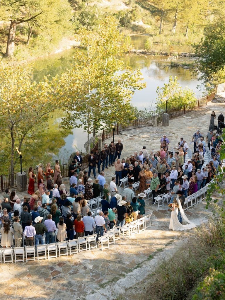 An outdoor wedding at Hideout on the Horseshoe—often booked for celebrations thanks to its wide-open space, scenic views, and prime Guadalupe River location. Credit: @moments.of.grace.photography via Instagram