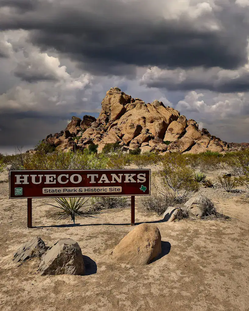 The Hueco Tanks State Park and Historic Site sign welcomes you with dramatic rock formations in the background, a premier destination for rock climbing. Credit: Victor Medina