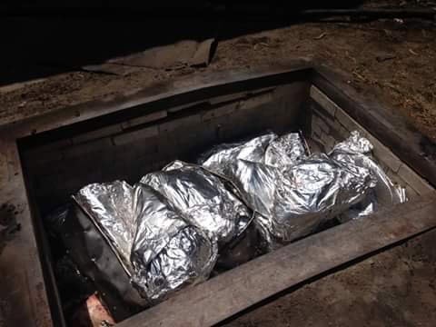 Loads of meat wrapped in bags are lowered into Vera’s smoke pit—their one-of-a-kind cooking method. Credit: Armando V.