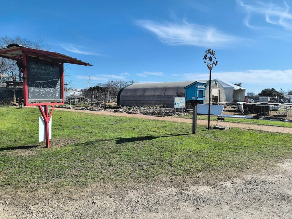 From the outside, Sunshine Gardens shows its sign, barn, and a simple chalkboard announcing seasonal sales. Credit: Andrea Golden