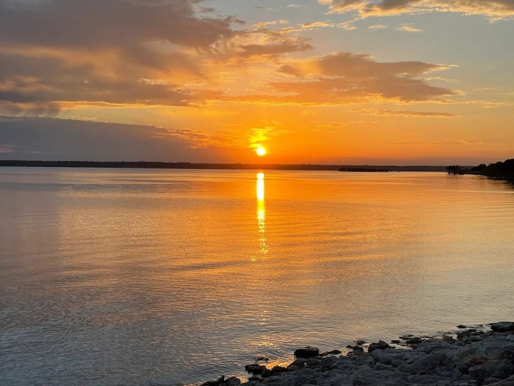 Sunset at Lake Whitney State Park paints calm waters in golden hues, a breathtaking end to the day. Credit: Myron Brown