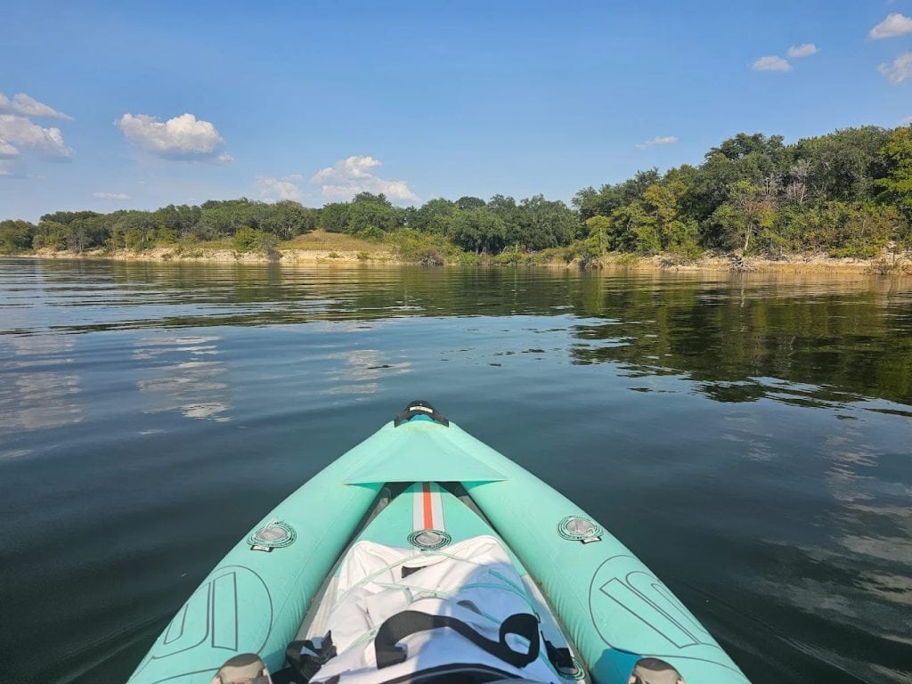 A POV shot captures kayaking and fishing adventures on Lake Whitney’s calm waters.