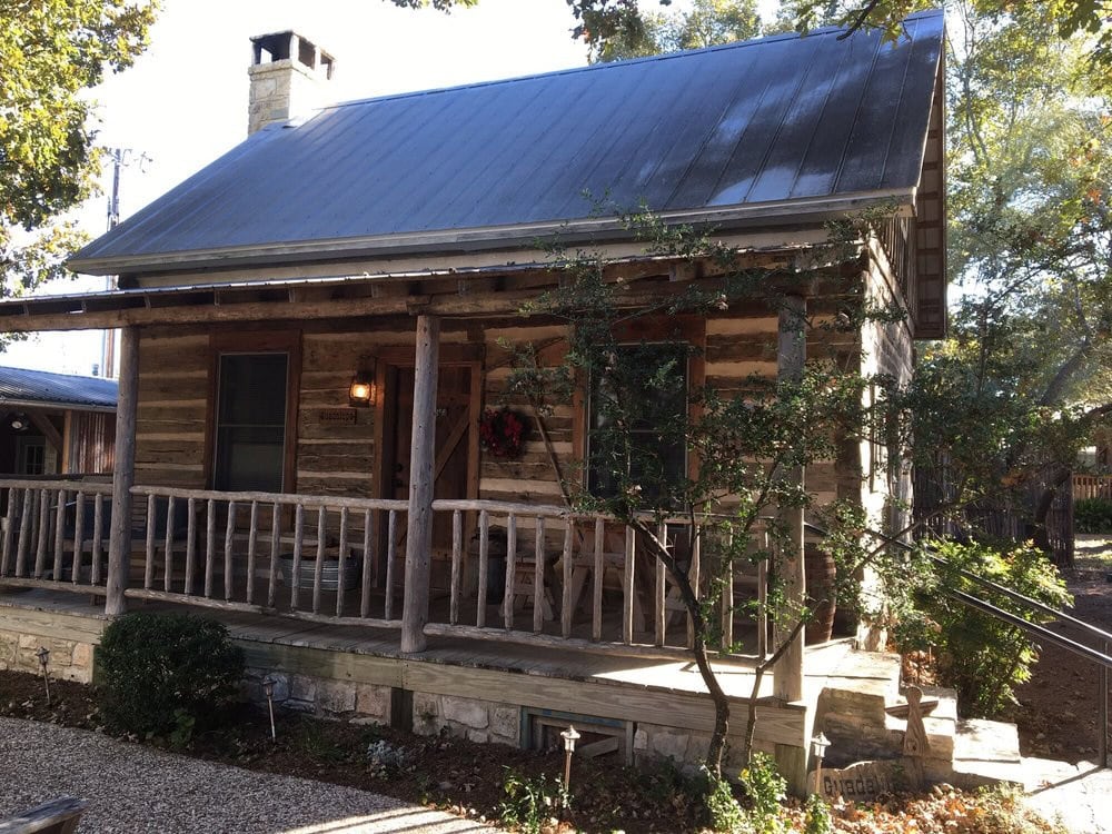 The Guadalupe Cabin features a wooden porch with table and chairs, perfect for outdoor dining in a rustic setting. Credit: Danny B.