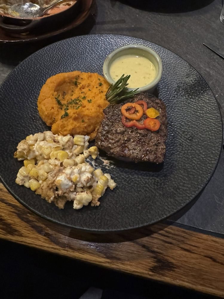 A hearty plate at Cabernet Grill includes steak, sweet potato, and Mexican corn—comfort food with flair. Credit: Oscar N.