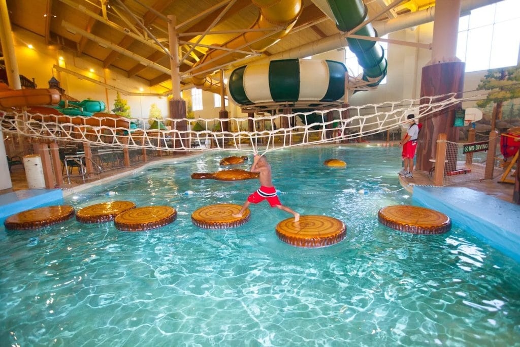 One of the lodge’s many pools includes playful activities like hopping across floating circles, with thrilling slides visible in the background. Credit: Great Wolf Lodge | Grapevine