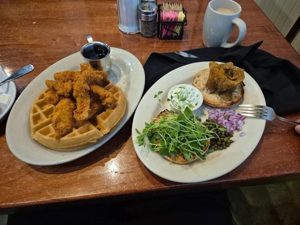 Buttermilk Café delights with chicken and waffles alongside house-cured salmon bagels with cream cheese and capers. Credit: 서인우