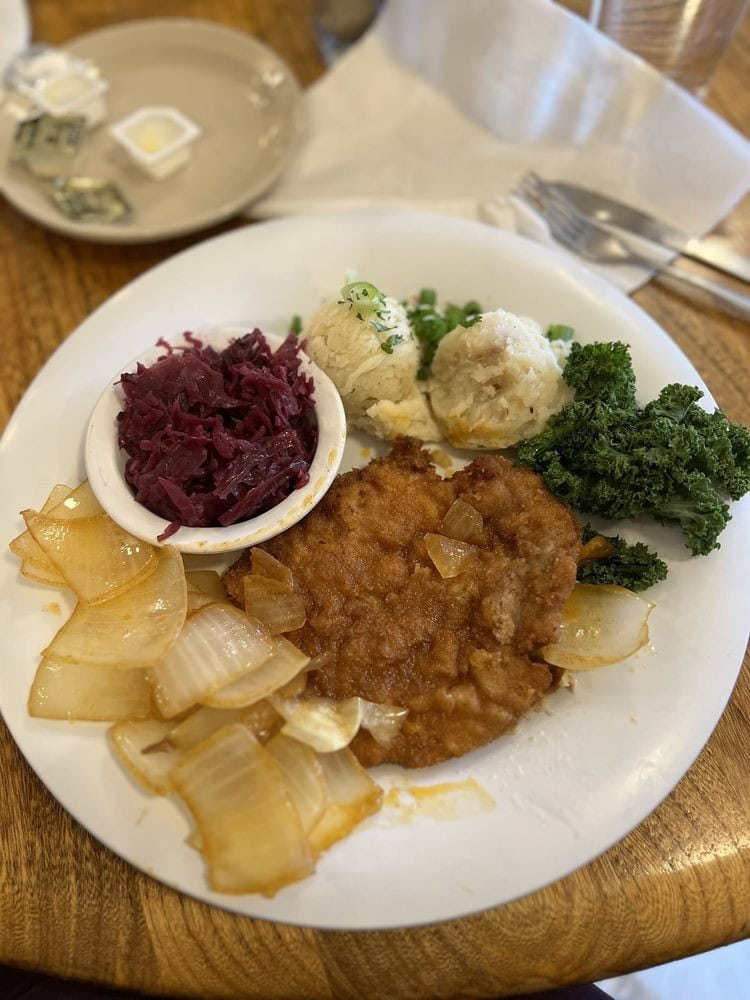 Zwiebel Schnitzel arrives smothered in caramelized onions, served with red cabbage and German potato salad. Credit: Reatha S.