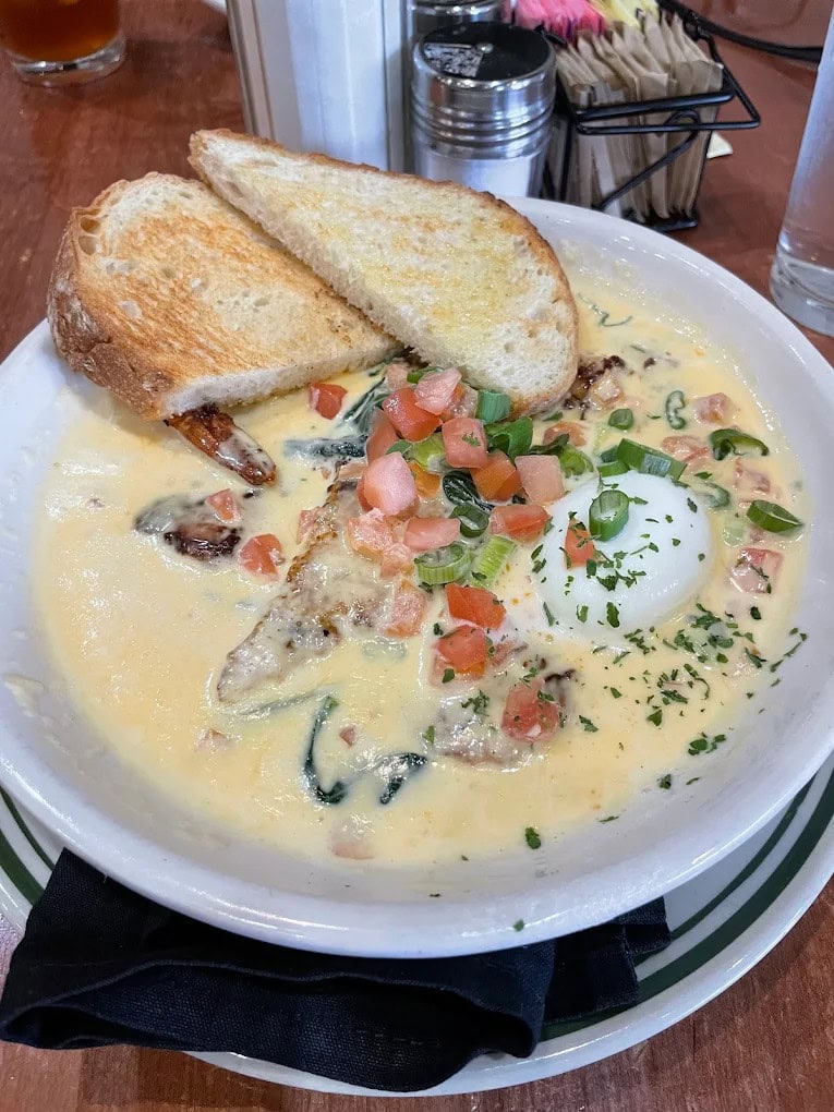 The coastal breakfast, a signature dish, features cheese grit polenta topped with shrimp, lobster sauce, and a poached egg. Credit: Laurie Herzer