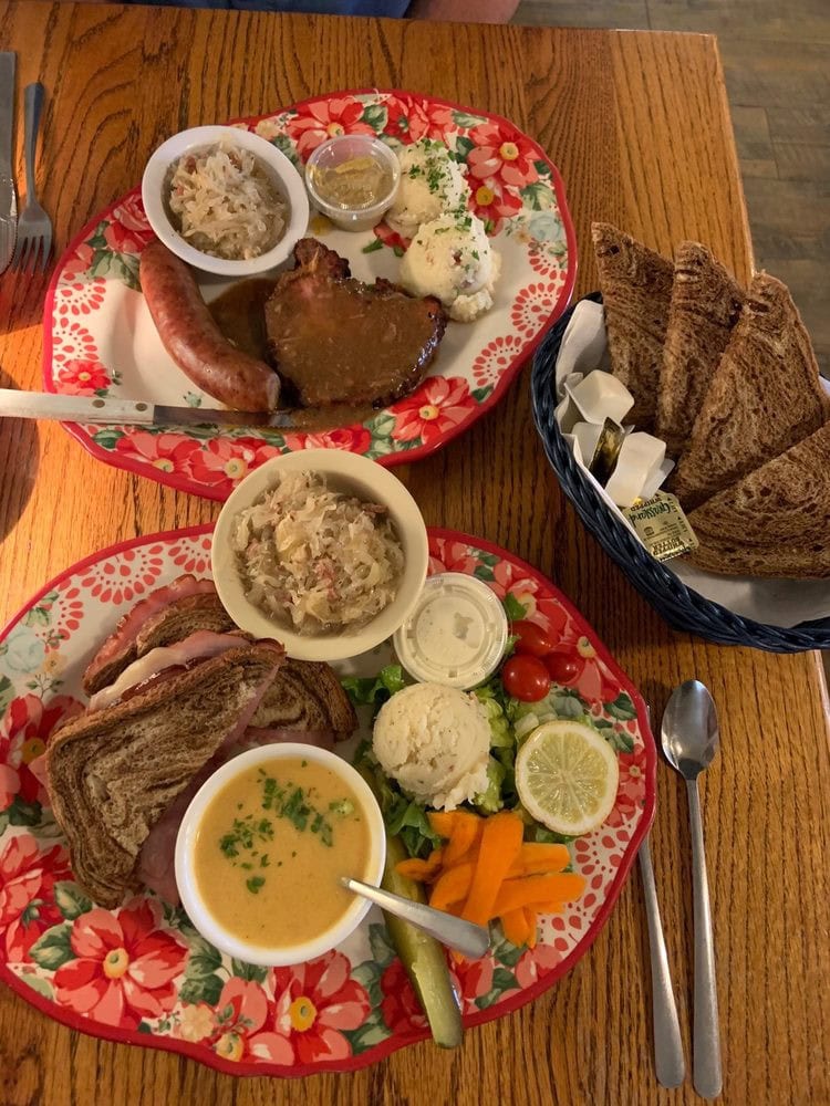 A table full of Der Lindenbaum specialties includes pork cutlet, sausage, sauerkraut, bread, soup, and a hearty ham sandwich. Credit: Stacey F.