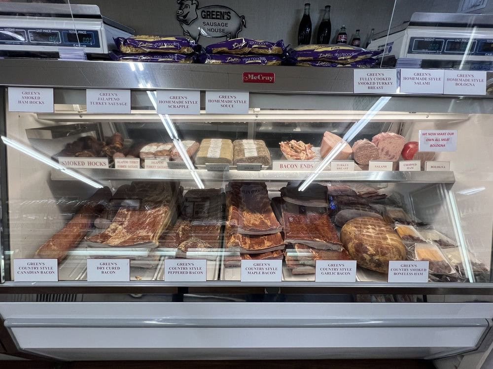Bacon and cured meats fill the deli display, highlighting Green’s dedication to quality. Credit: Grant B.