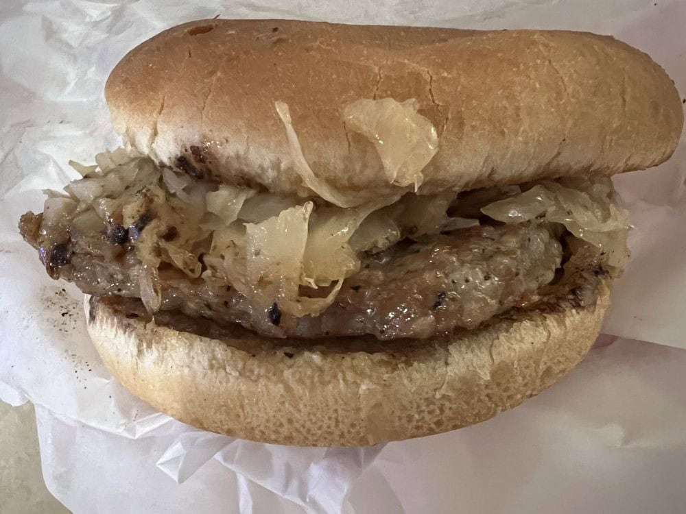 The Kraut Sausage Burger delivers bold flavor, a signature dish at Green’s. Credit: Grant B.