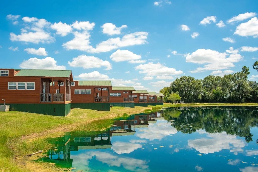 Cozy cabins sit right in front of a pond—imagine waking up to that peaceful scenery every morning. Credit: Jellystone Park™ Waller