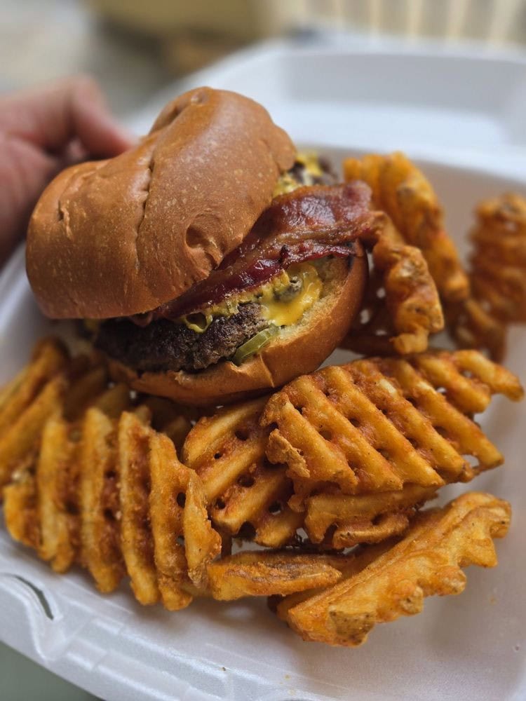 A classic bacon cheeseburger with crinkle-cut fries delivers timeless comfort. Credit: Daniel M.