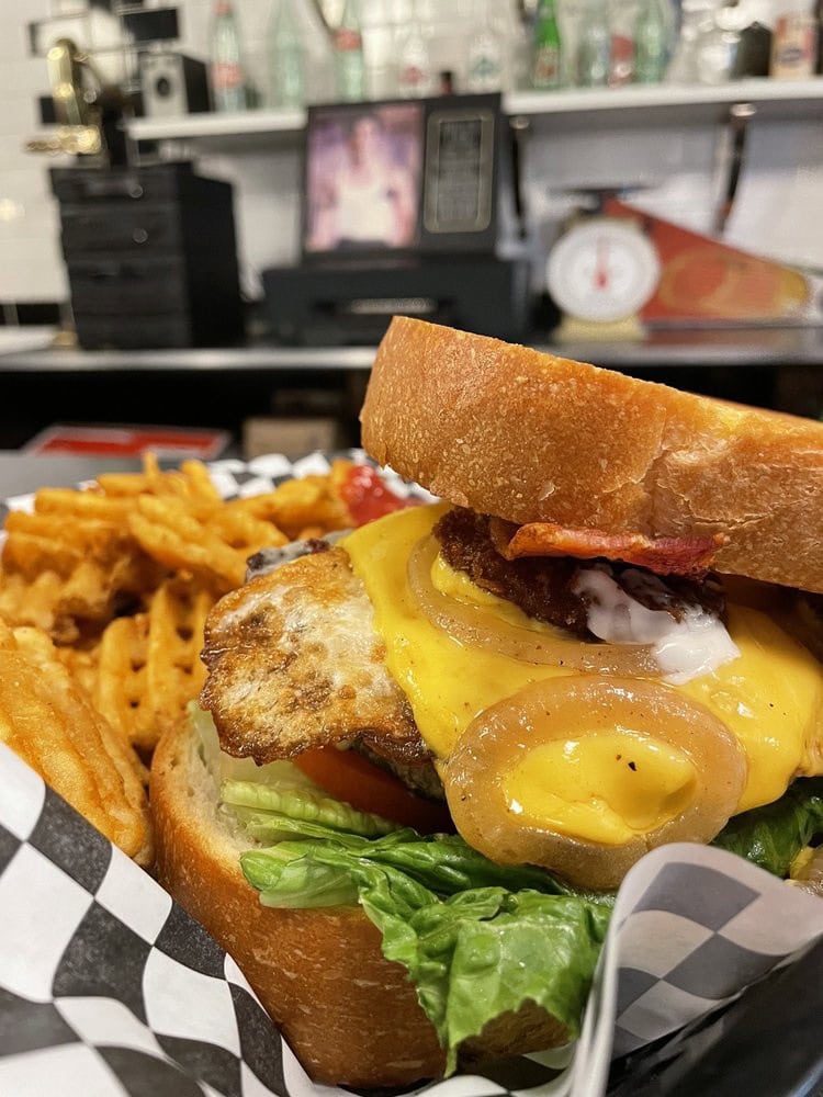 The Cowboy Brunch swaps buns for Texas toast, loaded with bacon, cheese, and fried pickles. Credit: David G.