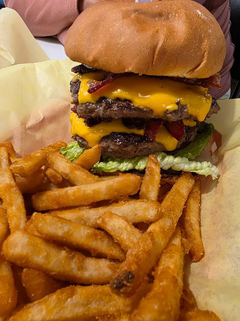 The Monster Burger challenges the hungriest guests with a towering stack of flavor. Credit: Paul Olivio