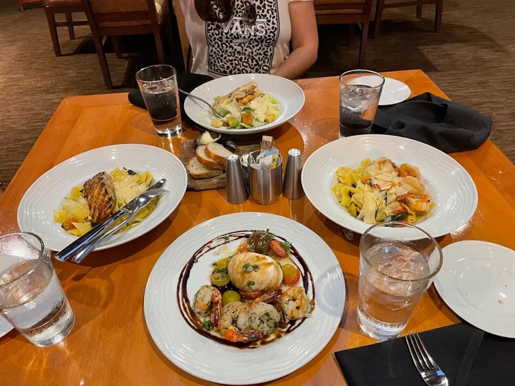A table spread from Sixty Three Restaurant & Bar showcases pasta, salad, and meats. Credit: gloria luna