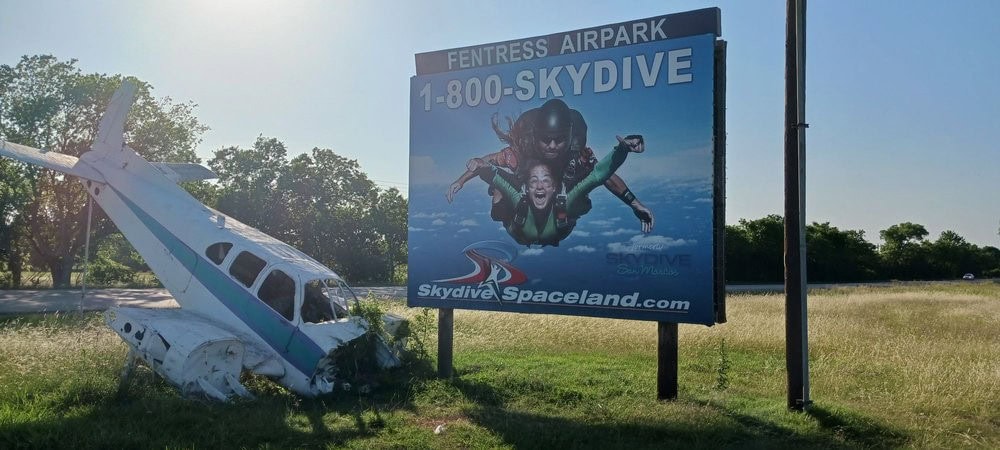 Skydive Spaceland’s billboard sign stands beside an old plane, a nod to its skydiving history. Credit: Hersh A.