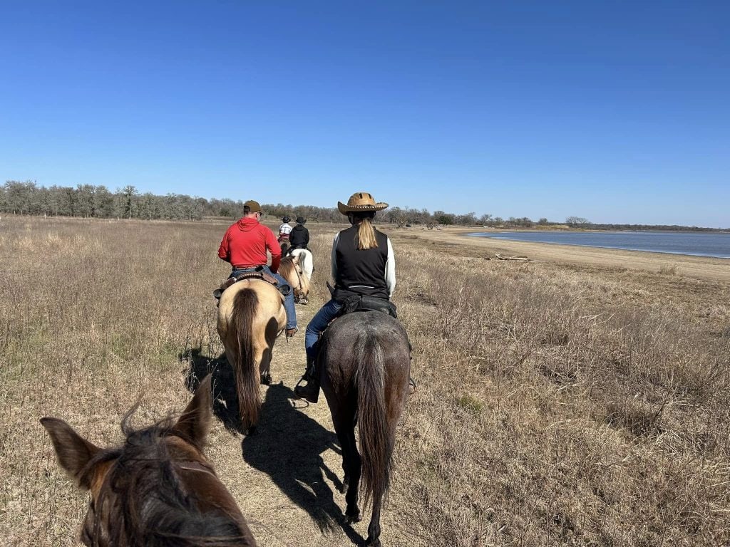 Groups of visitors ride horses together along the lakeside trail, enjoying the scenery. Credit: Barbara Rothermund Chopek