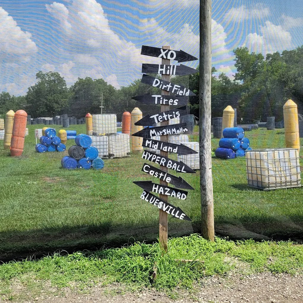 Arrow signages point to different playing fields, with obstacle-filled courses visible in the background. Credit: Danny Duplechian