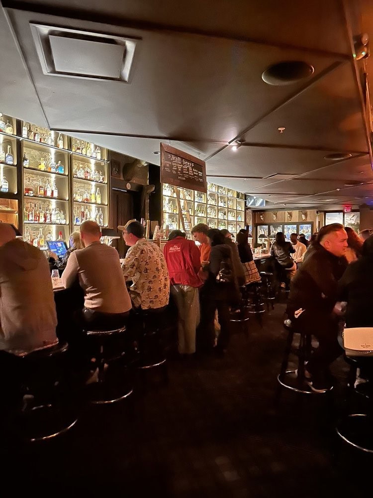 Locals and guests fill the long bar, with shelves stacked high with the varieties of tequila and mezcal served here. Credit: Jerry D.