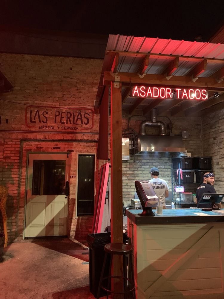 Asador Tacos operates on the patio with a neon sign, serving tacos alongside Las Perlas’ drinks—the perfect combo. Credit: Farhat K.