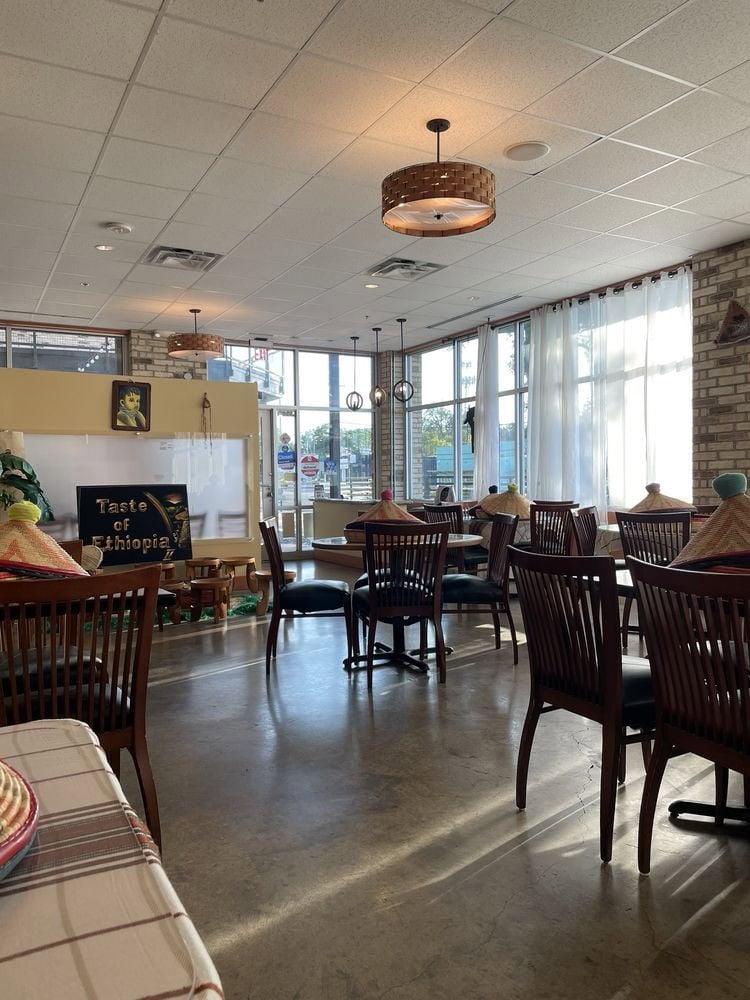 Inside Taste of Ethiopia, wooden tables and chairs complement Ethiopian décor, with a mesob basket at each table for injera. Credit: Paulina A.