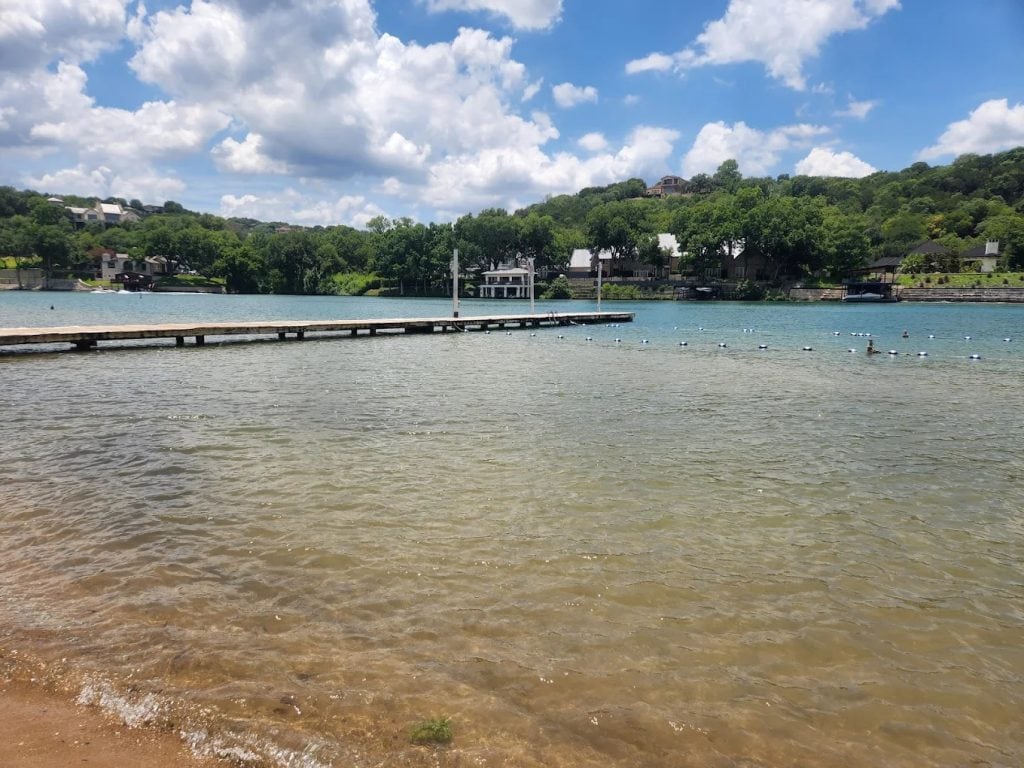 The lake at Emma Long Metropolitan Park stretches wide, surrounded by trees and a dock that makes the view unforgettable. Credit: Brittany Beane