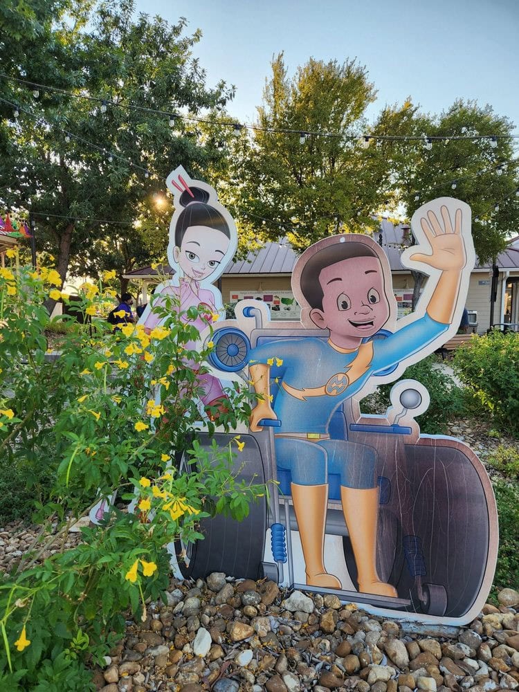 A creative cutout of children with crutches and wheelchairs dressed as superheroes proudly reflects the park’s commitment to inclusivity. Credit: Abbey A.