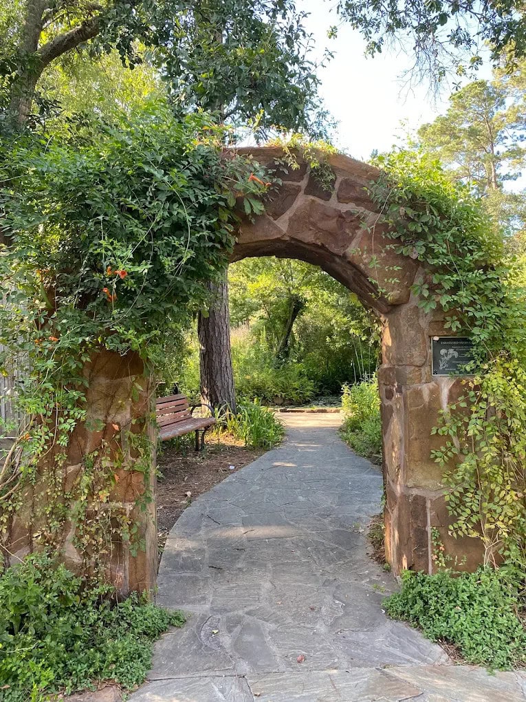 A brick archway with benches nearby invites visitors to relax and enjoy the peaceful surroundings. Credit: Albert Marquez