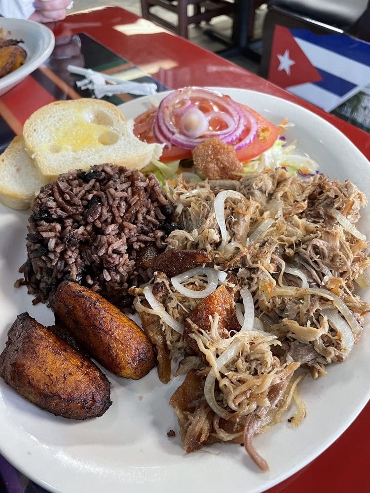 Lechón asado comes with bread, rice, fried plantains, and vegetables for a hearty Cuban meal. Credit: Robert F.
