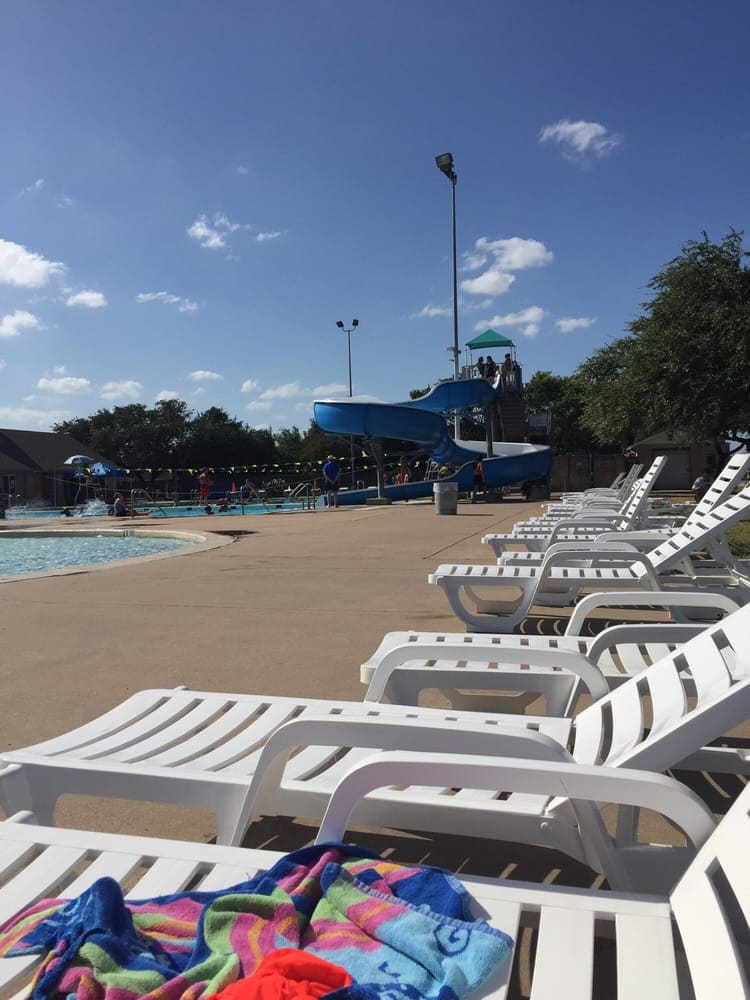 Beach chairs line the poolside for relaxation, while a towering slide in the background awaits older guests. Credit: Crystal D.