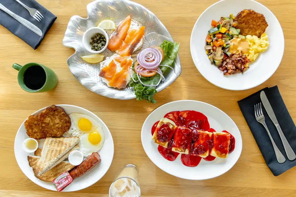 A full table spread at Katz’s tempts with salmon bagels, eggs and hash, veggies with mashed potatoes, desserts, and coffee. Credit: Katzs Never Kloses